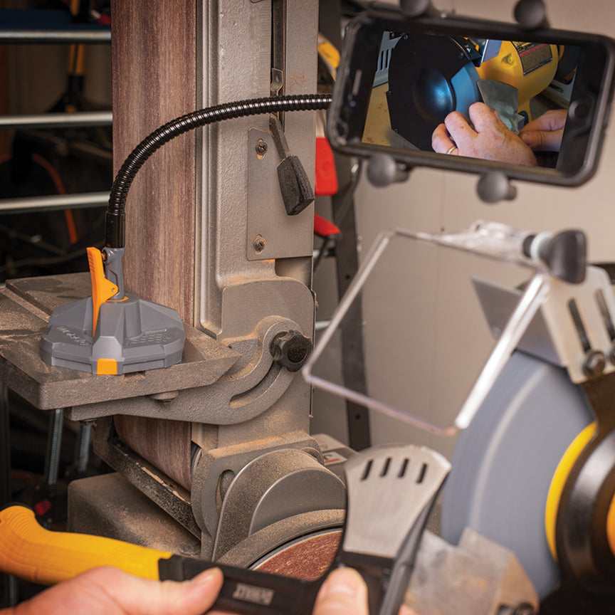 A phone on a mount capturing a worker using a grinder