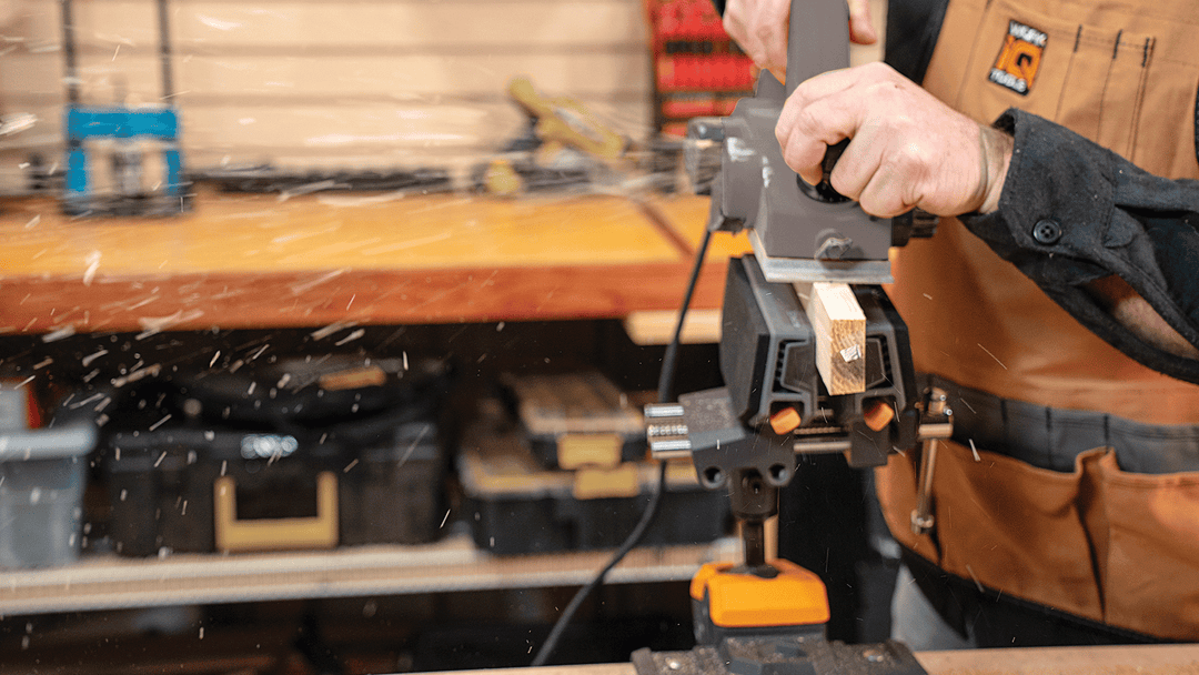 A person using an IQ Vise System to hold a workpiece while using a screwdriver.